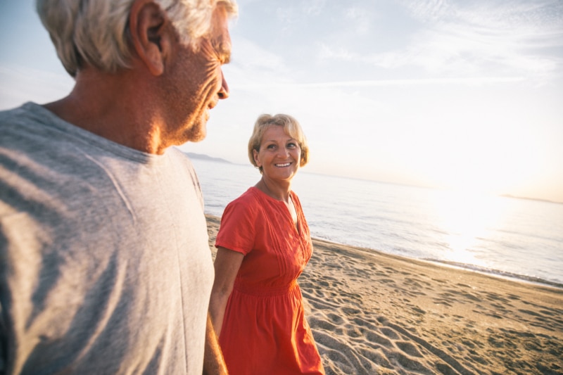 Older couple walking on beach